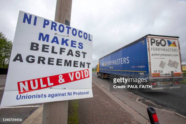 Lorry passes an anti 'Northern Ireland Protocol' sign as it is driven away from Larne port, north of Belfast in Northern Ireland, after arriving on a...