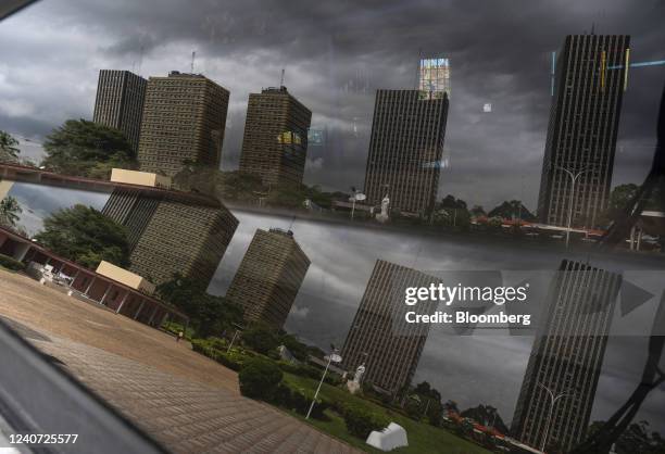 The main government administrative buildings reflected in a window on the St. Paul Cathedral compound in the Plateau business district of Abidjan,...