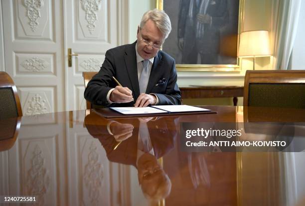 Finnish Foreign Minister Pekka Haavisto signs a petition for NATO membership in Helsinki on May 17, 2022. - Finland and Sweden will submit their bids...