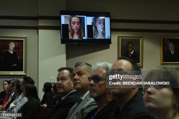 Spectators in the courtroom listen as evidence showing pictures of US actress Amber Heard appear on a screen during a defamation trial at the Fairfax...