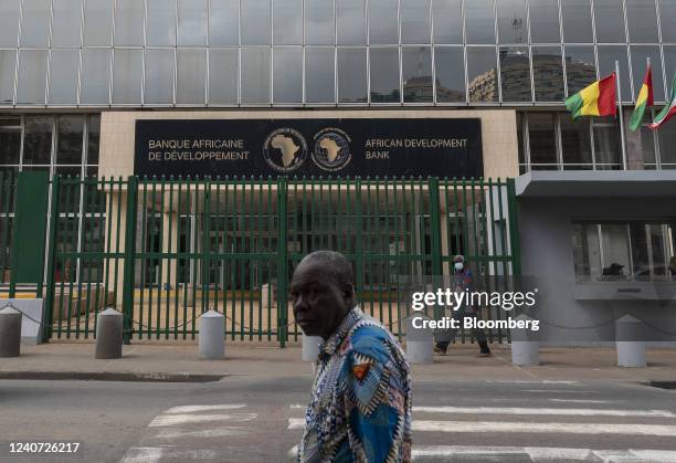 Pedestrians pass by headquarters for the African Development Bank in the Plateau business district of Abidjan, Ivory Coast, on Monday, May 16, 2022....