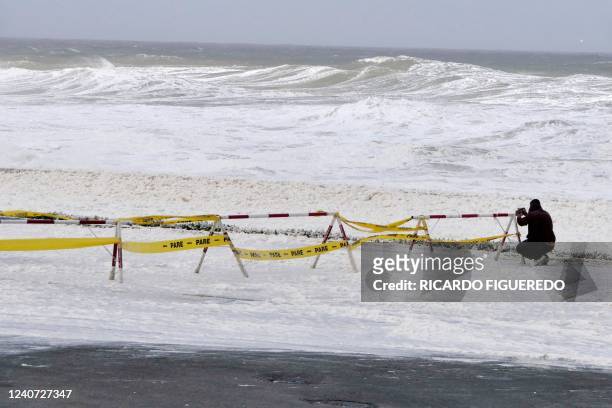 Man takes pictures of foam and sea spray covering the sea front promenade during the passage of a subtropical cyclone in Punta del Este, Uruguay, on...