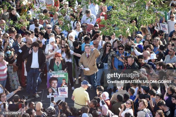 The leader of French leftist electoral coalition Nupes Jean-Luc Melenchon raises his fist to photographers next to Nupes local candidates Matthias...