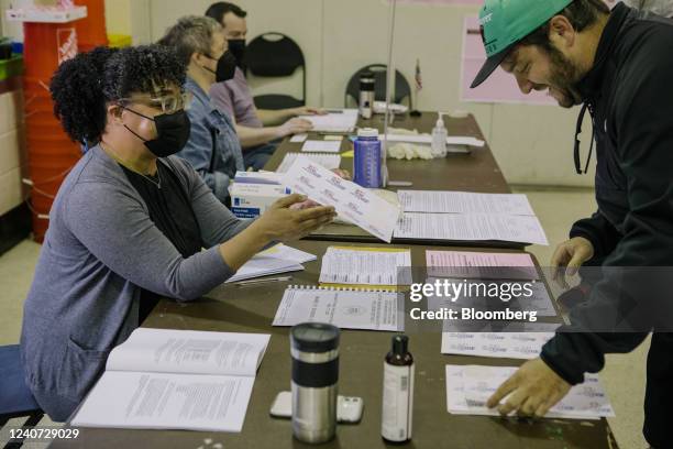 An election officials gives a voter an "I Voted!"sticker at a polling location in Philadelphia, Pennsylvania, US, on Tuesday, May 17, 2022....