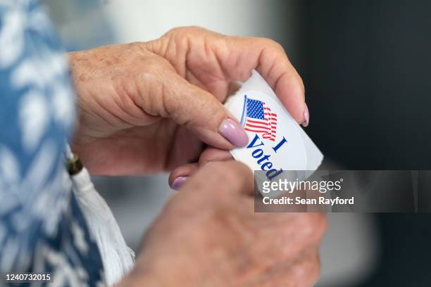 Poll worker holds a sticker that reads, I Voted on May 17, 2022 in Mt. Gilead, North Carolina. North Carolina is one of several states holding...