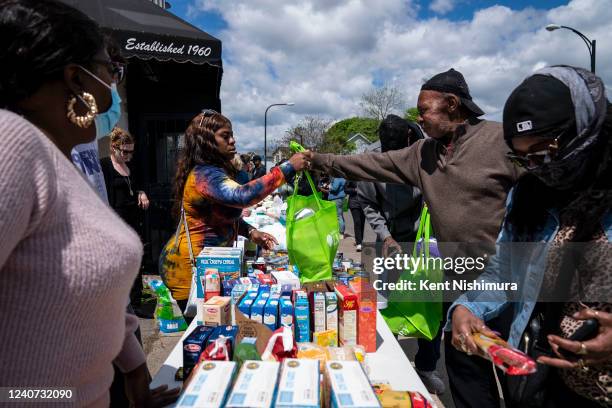 Eddie Colbert second from right, and others pick up food and supplies from a food distribution event put on by Buffalo Community Fridge along Ferry...