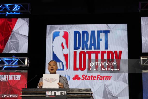 Deputy Commissioner of the NBA, Mark Tatum holds up the card of the New Orleans Pelicans after they get the 8th overall pick in the NBA Draft during...