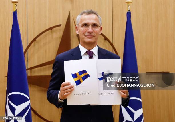 Secretary-General Jens Stoltenberg poses with application documents presented by Finland's Ambassador to NATO Klaus Korhonen and Sweden's Ambassador...