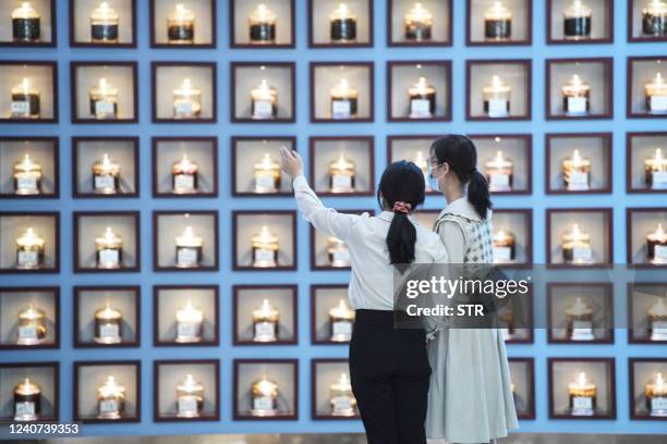 Visitors look at specimens of Chinese herbal medicine at a museum during the International Museum Day in Bozhou, in China's eatern Anhui province on...