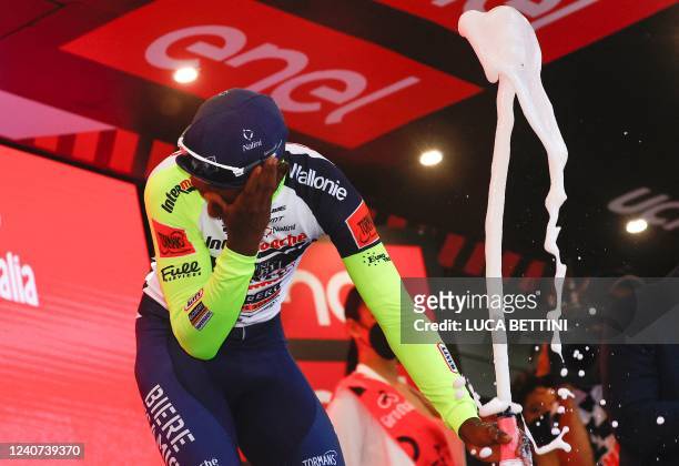 Team Wanty's Eritrean rider Biniam Girmay Hailu reacts after popping a champagne cork as he celebrates on the podium after winning the 10th stage of...