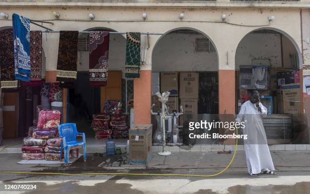 Vendor hoses the road in front of his store to keep dust down in N'Djamena, Chad, on Tuesday, May 10, 2022. Last year, Chad became the first country...