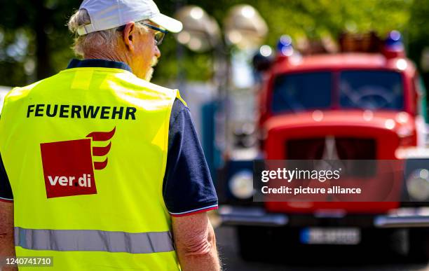 May 2022, Lower Saxony, Hanover: The words "Feuerwehr - verdi" can be read on a demonstrator's high-visibility vest during the 24-hour demonstration...