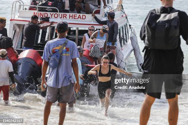 Foreign tourist disembarks a boat arriving from Nusa Penida Island at Sanur Harbour in Denpasar, Bali, Indonesia on May 18, 2022. Indonesian...