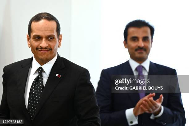 Emir of Qatar Tamim bin Hamad Al Thani and Qatar's Foreign Minister Sheikh Mohammed bin Abdulrahman Al Thani react after signing commercial contrats...