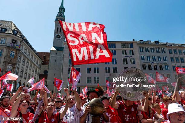 Fans of FC Bayern Muenchen ,with flags,banner during the official Bundesliga championship celebration at Marienplatz on May 15, 2022 in Munich,...