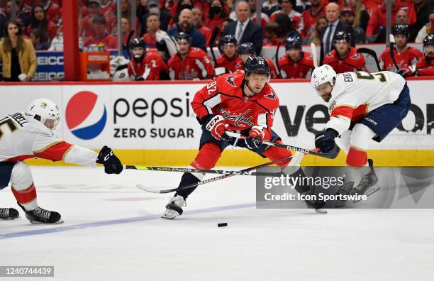 Panthers center Anton Lundell and defenseman Aaron Ekblad try to slow down Capitals center Evgeny Kuznetsov as he skates across the blue line during...