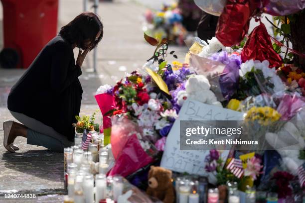 Shannon Waedell-Collins pays her respects after placing flowers at a makeshift memorial across the street from Tops Friendly Market at Jefferson...