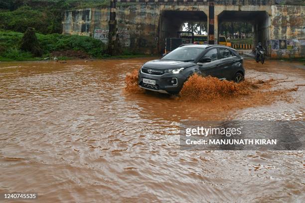 Motorists make their way through a waterlogged road after a rain shower in Bangalore on May 18 as the Indian Meteorological Department warned of...
