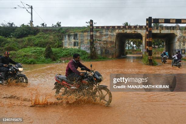 Motorists make their way through a waterlogged road after a rain shower in Bangalore on May 18 as the Indian Meteorological Department warned of...