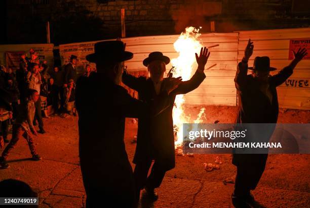 Ultra-Orthodox Jewish men dance around a bonfire in Jerusalem's Mea Shearim neighbourhood on May 18 as people gather to celebrate the Jewish holiday...