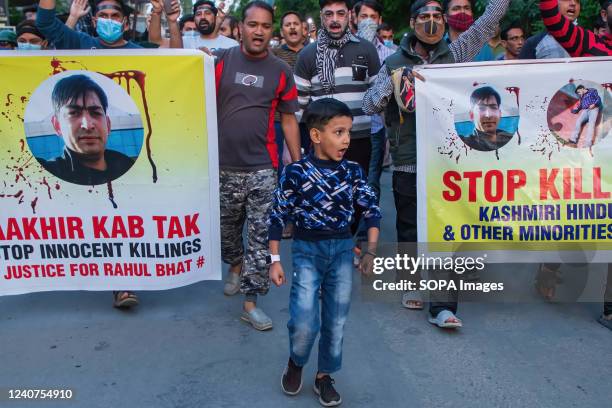 Kashmiri Hindus, locally known as "pandits" march with banners as they shout slogans during the protest in Budgam against the killing of Rahul Bhat a...