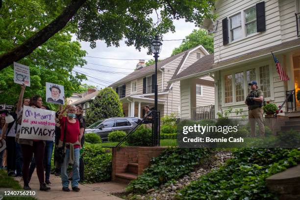 Police officers look on as abortion-rights advocates hold a demonstration outside the home of U.S. Supreme Court Justice Brett Kavanaugh on May 18,...