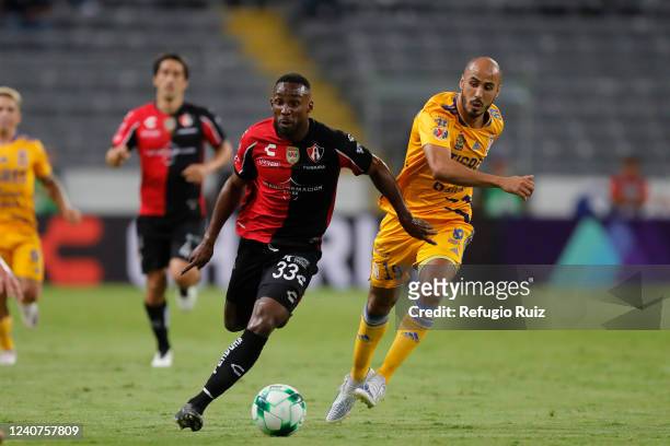 Julian Quiñones of Atlas fights for the ball with Guido Pizarro of Tigres during the semifinal first leg match between Atlas and Tigres UANL as part...