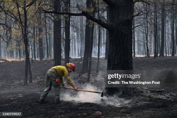 Firefighter works on putting out a hotspot from a wildfire on Friday May 13, 2022 in Mora, NM. The Calf Canyon and Hermits Peak fires have been...