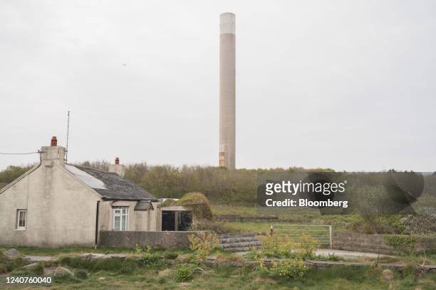 Residential cottage, backdropped by the chimney of a former aluminium plant in Anglesey, UK, on Saturday, April 30, 2022. Anglesey is where the...