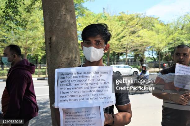 Rohingya refugee holding placard participates in a protest. Hundreds of Rohingya refugees from Myanmar who have lived in Indonesia for a dozen years...