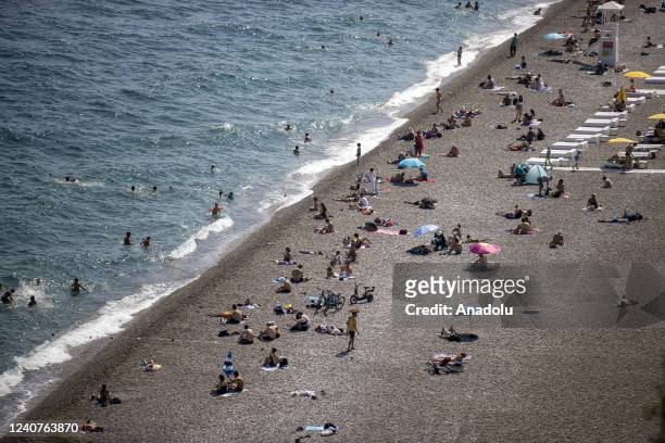 Tourists enjoy the sunny day at a beach in Antalya, Turkiye on May 19, 2022.