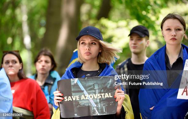 Demonstrators hold placards during the Save Mariupol rally in Mariinskyi Park opposite the Embassy of the People's Republic of China as they call on...