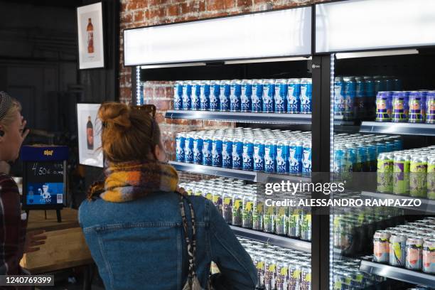 Customers look at the new OTAN beer on display in a fridge in the brewery shop of Olaf brewery on May 19, 2022 in the brewery's shop in Savonlinna,...