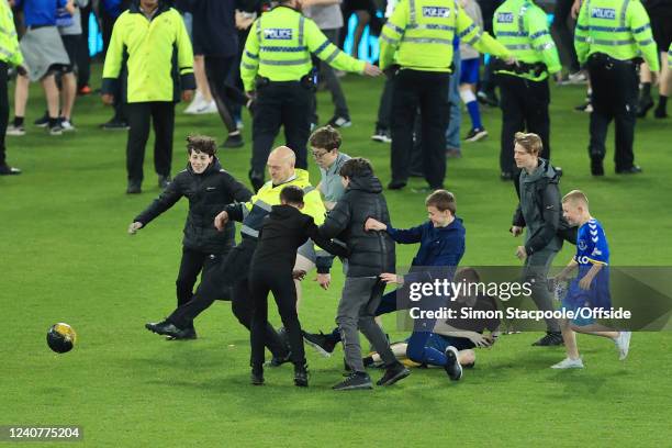 Steward plays football with Everton fans on the pitch after the Premier League match between Everton and Crystal Palace at Goodison Park on May 19,...