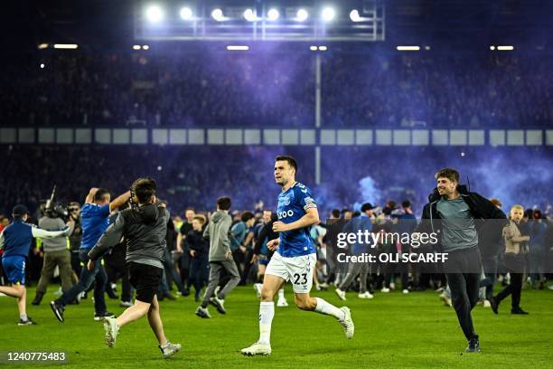 Everton's Irish defender Seamus Coleman celebrates with Everton's fans invading the football pitch to celebrate at the end of the English Premier...