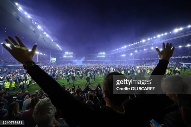 Everton's fans invade the football pitch to celebrate at the end of the English Premier League football match between Everton and Crystal Palace at...