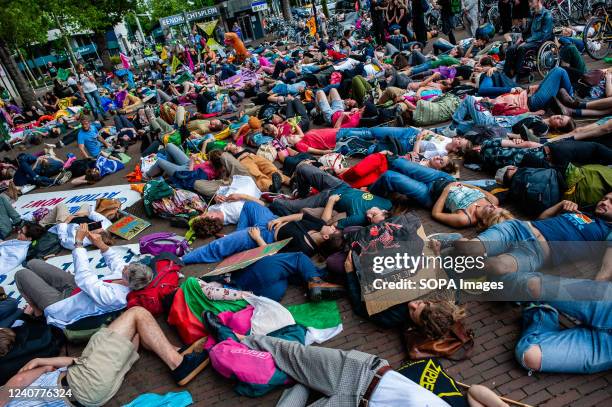 Hundreds of climate activists are seen laying on the ground pretending to be dead during the demonstration. With this protest, the climate...