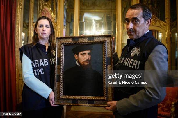 The painting 'Portrait of a gentleman in a black cap' attributed to Titian is held by members of the Carabinieri of the Cultural Heritage Protection...