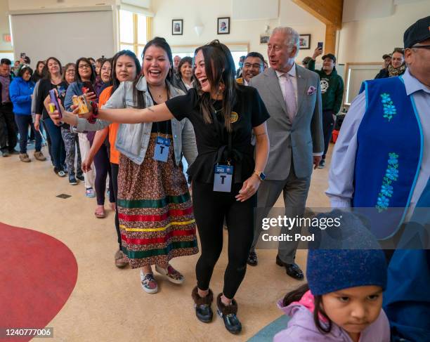 Prince Charles, Prince of Wales joins in a Dene dance while visiting the Dettah Community during a three-day trip to Canada with the Duchess of...