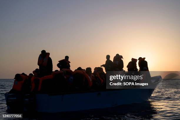 Migrants seen standing and sitting in a wooden boat. The crew of Astral sailboat, of the Spanish NGO Open Arms, carried out a rescue for nearly 70...