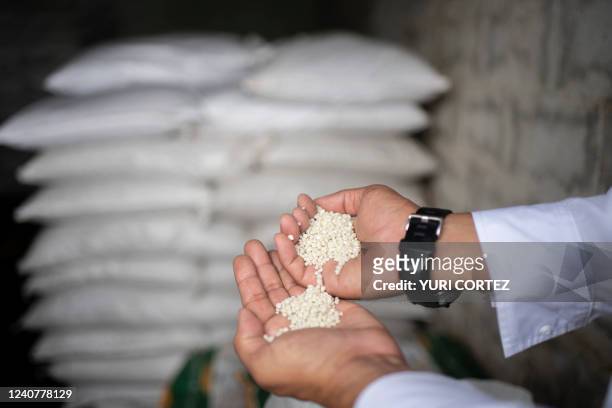 Alexis Gomez, member of the Association of Independent Agricultural Producers, speaks during an interview while showing bags containing fertilizer...