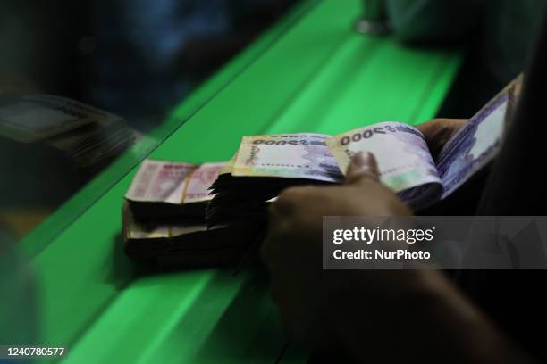 Customer counts Bangladeshi taka after exchanging dollars from a money exchange booth in Dhaka, Bangladesh on May 19, 2022.