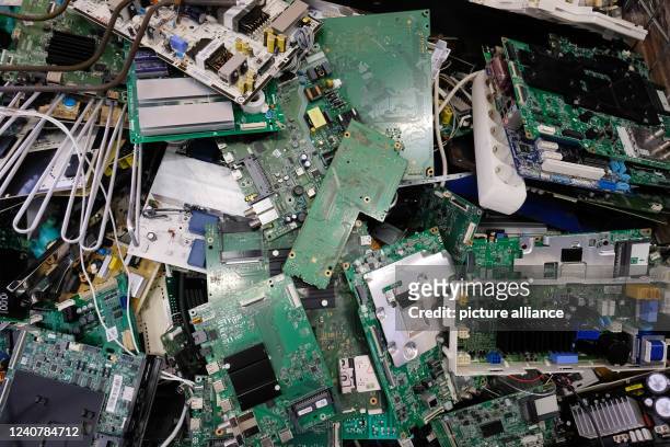 May 2022, Saxony, Leipzig: Printed circuit boards and components of electrical devices in a box for electronic waste in a repair workshop. On the...
