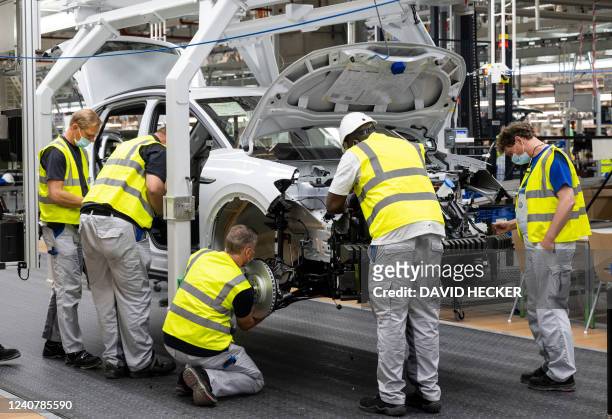 Employees work at the assembly line of the Volkswagen ID 4 electric car of German carmaker Volkswagen, in the production site of Emden, northern...