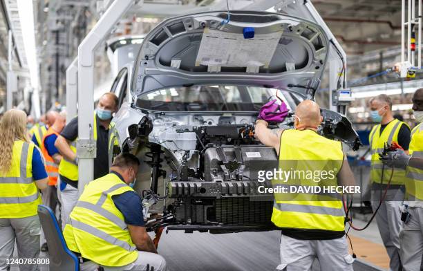 Employees work at the assembly line of the Volkswagen ID 4 electric car of German carmaker Volkswagen, in the production site of Emden, northern...