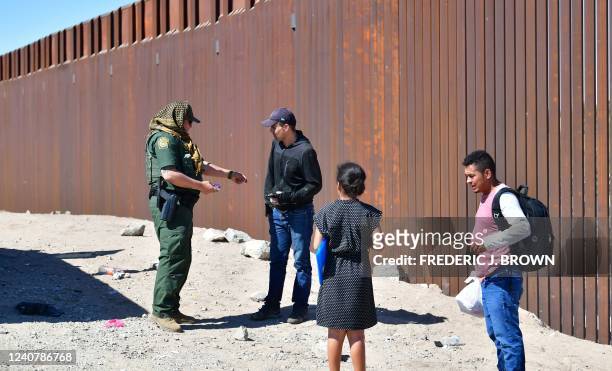 Border Patrol officer deals with migrants arriving at the US-Mexico border between Algodones, Mexico, and Yuma, Arizona, on May 16, 2022. - A US...