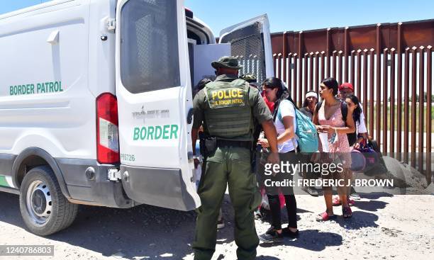 Migrants board a US Border Patrol van after crossing into the US from Mexico through a gap in the border wall between Algodones, Mexico, and Yuma,...