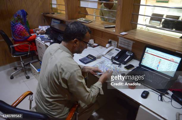 Foreign currency dealer counts US dollars at a money exchange company in Karachi, Pakistan, 20 May 2022. The Pakistan rupee dropped to a historic low...