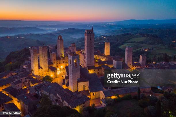 General aerial drone view before sunrise of historical centre of San Gimignano , Italy, on may 15, 2022. San Gimignano is a UNESCO heritage village...