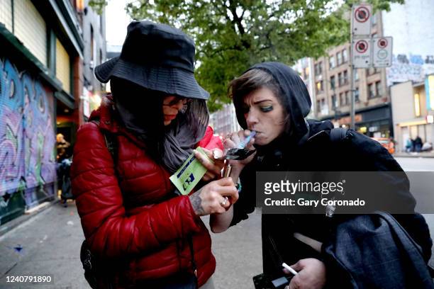 Shyan Willow left, and Kia Haim smoke fentanyl along East Hastings Street in the Downtown Eastside neighborhood on Tuesday, May 3, 2022 in Vancouver,...